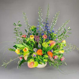 Colorful mixed flower arrangement in a white bowl vase
