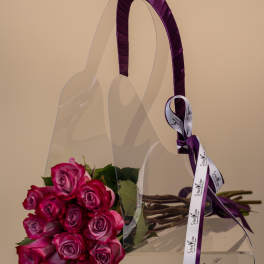 Pink and purple rose bouquet in a clear handbag-shaped box with ribbon