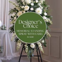 White standing funeral spray on a black easel