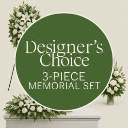 White floral memorial set with lilies and roses around a green sign