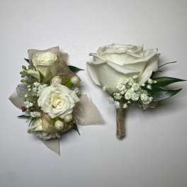 Two white rose boutonnieres with gold ribbon and baby's breath