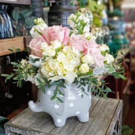 Pink and white roses arranged in a polka-dot elephant vase