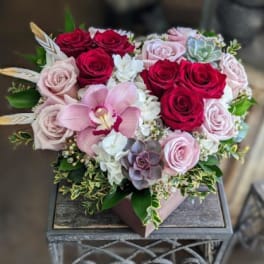 Bouquet of red and blush roses with a pink orchid and succulents