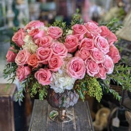 Pink roses and white hydrangeas arranged in a decorative vase