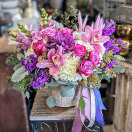 Pink and purple floral arrangement in a patterned ceramic pot