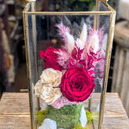 Glass terrarium with red and cream roses and pink dried accents