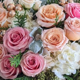 Pink and peach roses with white hydrangeas and decorative berries