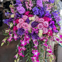 Large standing arrangement of pink, purple, and white flowers