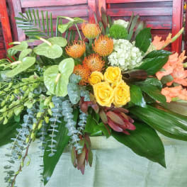 Tropical floral arrangement with yellow roses, orange blooms, and peach gladiolus