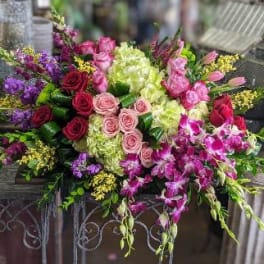 Large mixed bouquet with pink and purple flowers in a decorative container