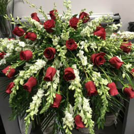 Large red rose and white flower arrangement with cascading greenery