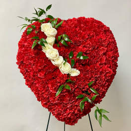 Heart-shaped red carnation arrangement with white roses and greenery