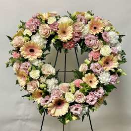 Heart-shaped floral wreath with pink, cream, and peach flowers