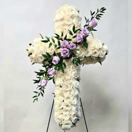 White rose cross with lavender roses and greenery on a stand