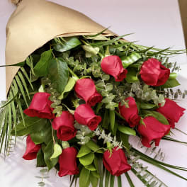 Bouquet of red roses wrapped in brown paper