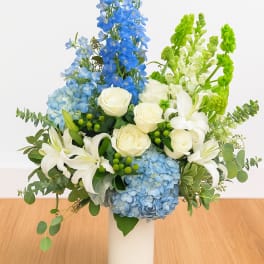 Blue and white floral arrangement in a white vase