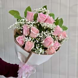 Bouquet of pink roses with white baby's breath in white wrap