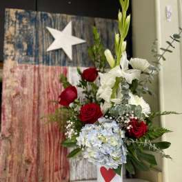 Red roses and white flowers in a white vase with a red heart