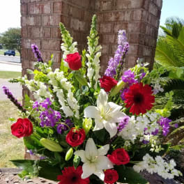 Mixed bouquet with red roses, white lilies, and purple flowers in a vase
