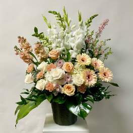 Mixed bouquet with white and peach flowers in a dark vase