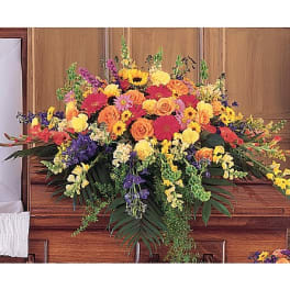 Large colorful floral arrangement on a wooden casket
