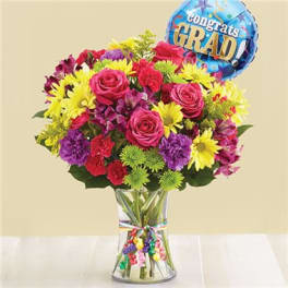 Colorful bouquet in a clear vase with a graduation balloon