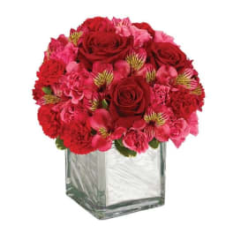 Red and pink bouquet in a square glass vase