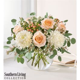 Peach roses and white mums in a clear glass vase