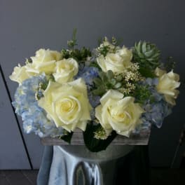 White roses and blue hydrangeas in a rectangular box arrangement