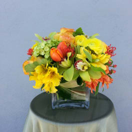 Bright mixed bouquet in a square glass vase
