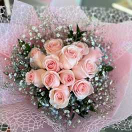 Bouquet of pale pink roses wrapped in pink paper