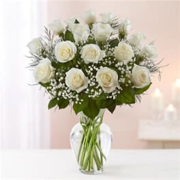 White roses arranged in a clear glass vase