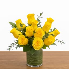 Yellow roses arranged in a green glass vase