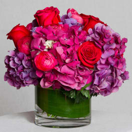 Pink and purple flower arrangement in a clear glass vase