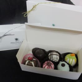 Box of assorted decorated chocolates in white gift boxes