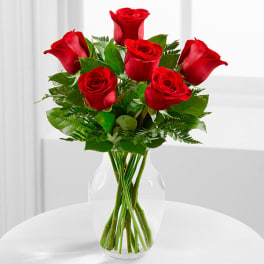 Red roses arranged in a clear glass vase