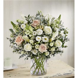 Bouquet of white and blush roses in a clear glass vase