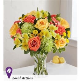 Bouquet of yellow and coral roses in a clear glass vase