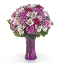 Pink and white mixed bouquet in a purple glass vase