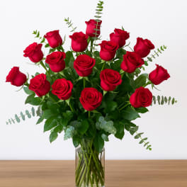 Red roses arranged in a clear glass vase