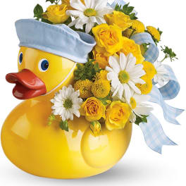 Yellow duck-shaped vase with yellow and white flowers and blue ribbon