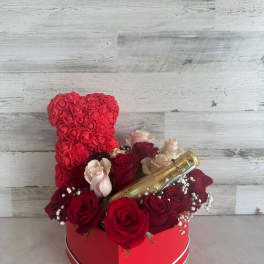 Heart-shaped rose arrangement with a champagne bottle in a red box