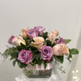 Arrangement of pink and peach roses in a glass vase