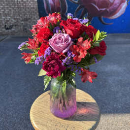 Bouquet of red and lavender roses in a glass vase