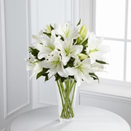 White lilies arranged in a clear glass vase