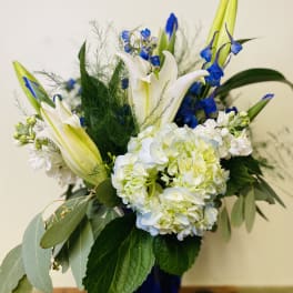 Blue and white floral arrangement in a dark vase
