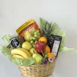 Fruit basket with bananas, pears, grapes, oranges, and snack boxes