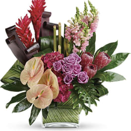 Tropical bouquet with pink roses, anthuriums, and red ginger in a glass vase