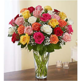 Mixed roses in a clear glass vase on a table