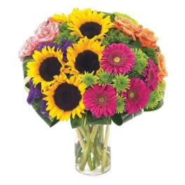 Bouquet of sunflowers, pink gerberas, and roses in a glass vase